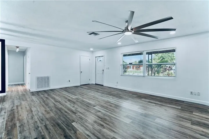 Empty room with ceiling fan, dark wood-style flooring, and recessed lighting