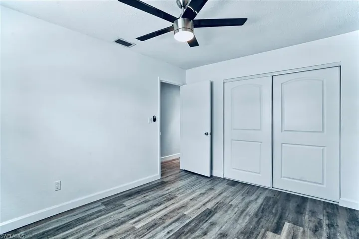 Unfurnished bedroom featuring wood finished floors, a closet, a ceiling fan, and a textured ceiling