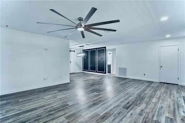 Empty room featuring ceiling fan, dark wood-style flooring, recessed lighting, and a textured ceiling