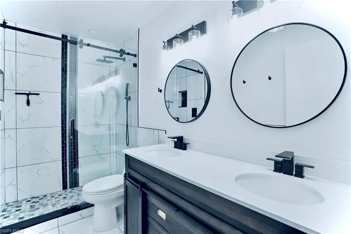 Bathroom featuring double vanity and a shower stall