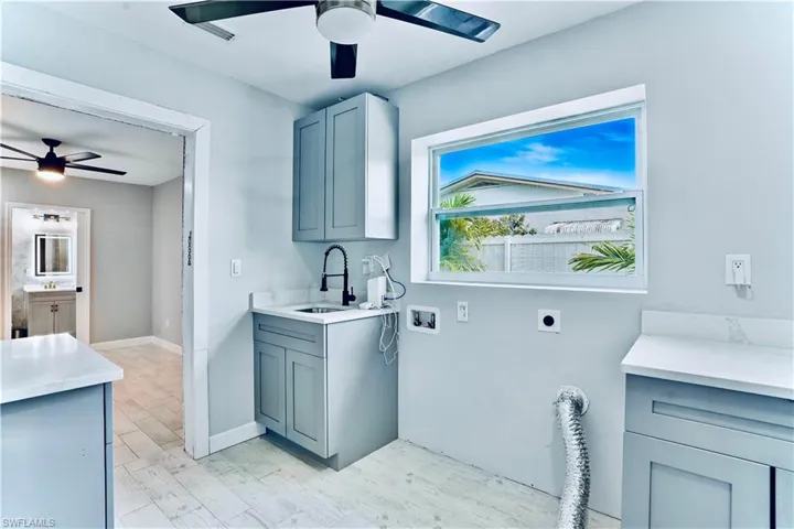 Laundry area featuring hookup for an electric dryer, ceiling fan, washer hookup, and cabinet space