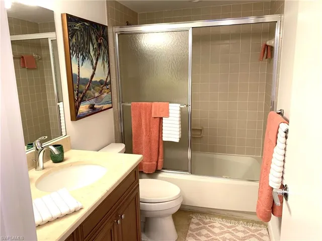 Full bathroom with vanity and combined bath / shower with glass door