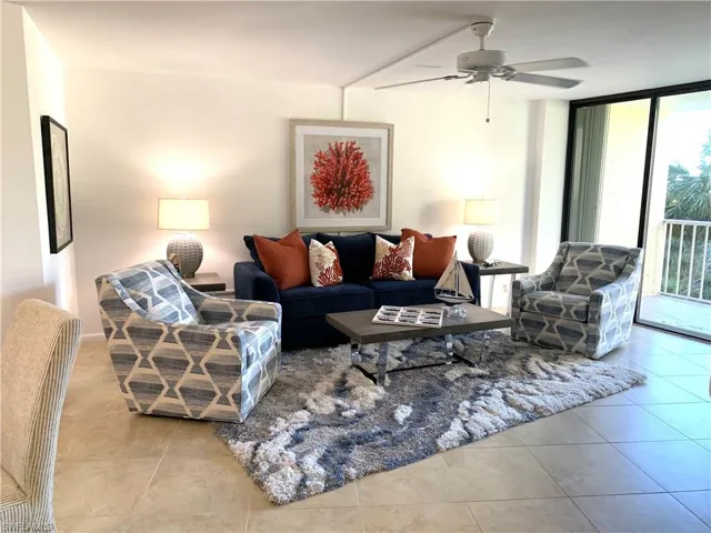 Living area with floor to ceiling windows, a ceiling fan, and light tile patterned floors