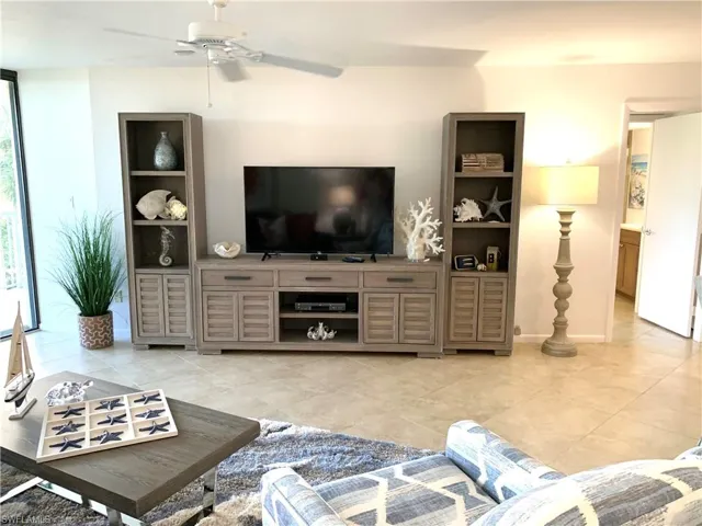 Living area featuring a ceiling fan and light tile patterned floors