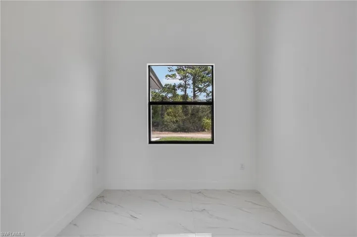 Spare room with light marble finish flooring and baseboards