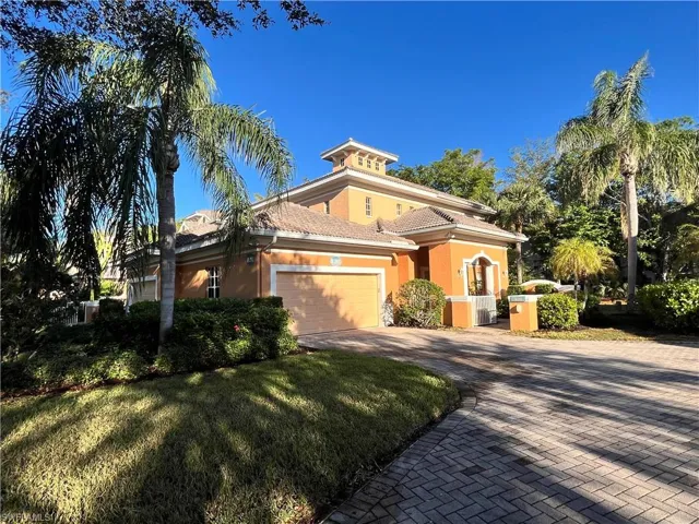 Mediterranean / spanish-style home with a garage and a front lawn