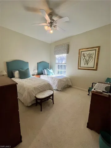 Carpeted bedroom featuring ceiling fan