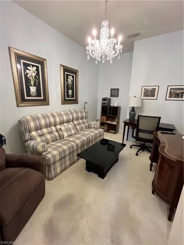 Living room with carpet flooring and a chandelier