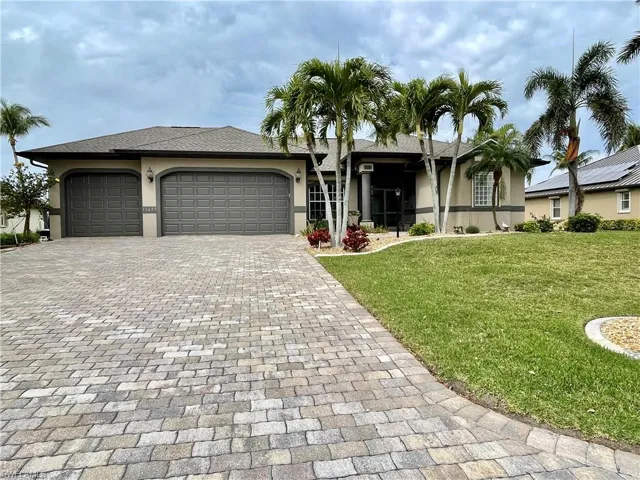 View of front of home with a garage and a front lawn