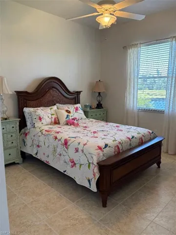 Bedroom with ceiling fan and light tile patterned floors