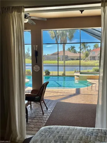 View of pool featuring ceiling fan and a water view