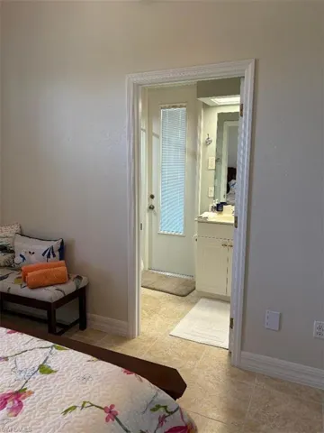 Bedroom featuring ensuite bathroom and light tile patterned floors