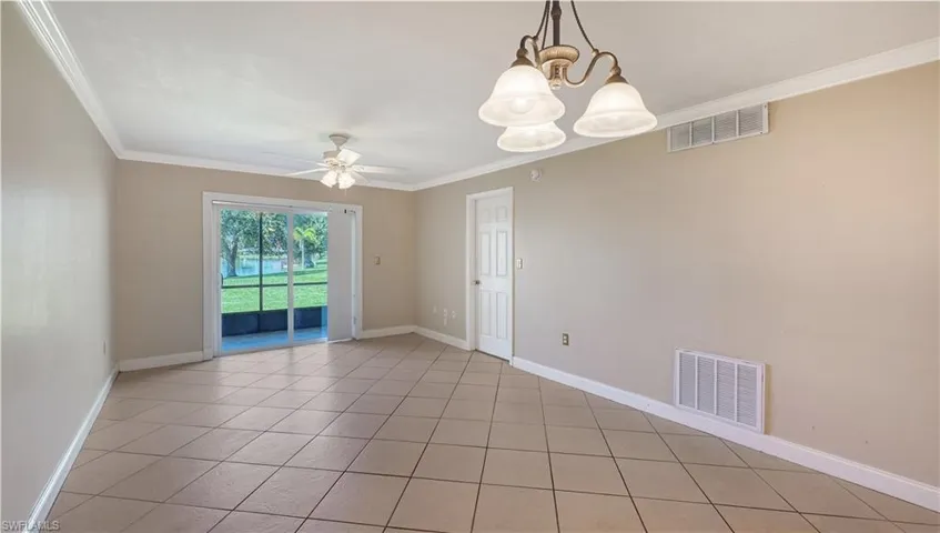 Unfurnished room featuring ornamental molding, a chandelier, light tile patterned floors, and a ceiling fan