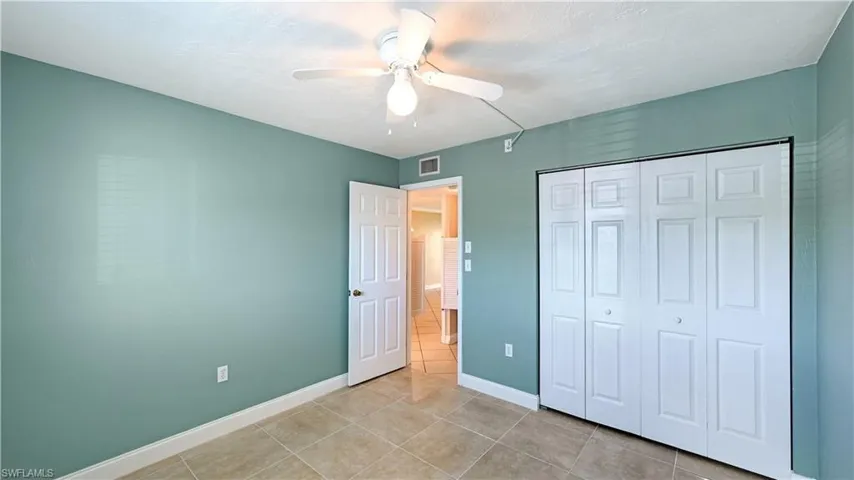 Unfurnished bedroom featuring a ceiling fan, a closet, and tile patterned flooring