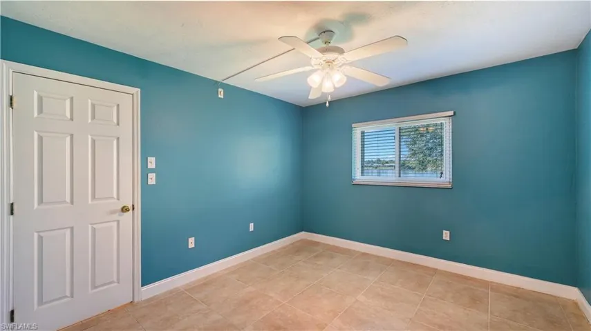 Unfurnished room with ceiling fan and light tile patterned flooring