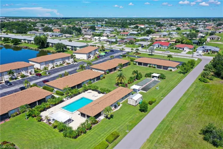 Aerial view of residential area featuring a pool and a large body of water