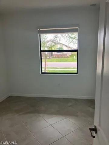 Unfurnished room with light tile patterned flooring