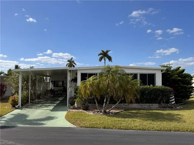 Manufactured / mobile home with a front lawn and a carport