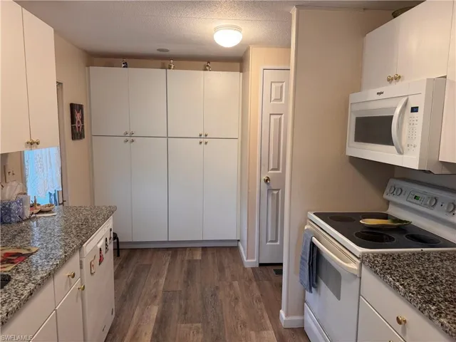 Kitchen featuring white cabinetry, granite countertops, soft close bottom cabinets, double pantry and separate broom closet