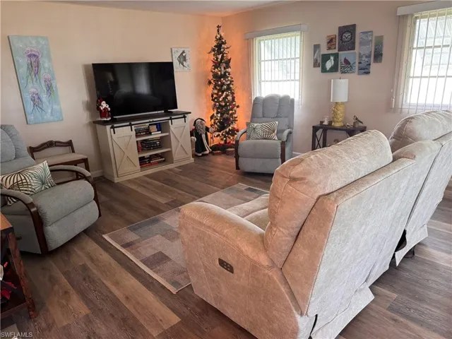 Living room featuring laminate flooring, custom window treatments.