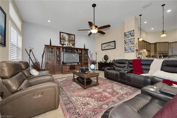 Living area featuring ceiling fan, light tile patterned flooring, and recessed lighting