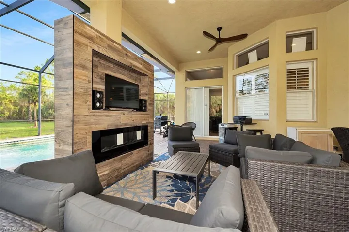 View of patio with an outdoor hangout area, a ceiling fan, glass enclosure, and an outdoor pool