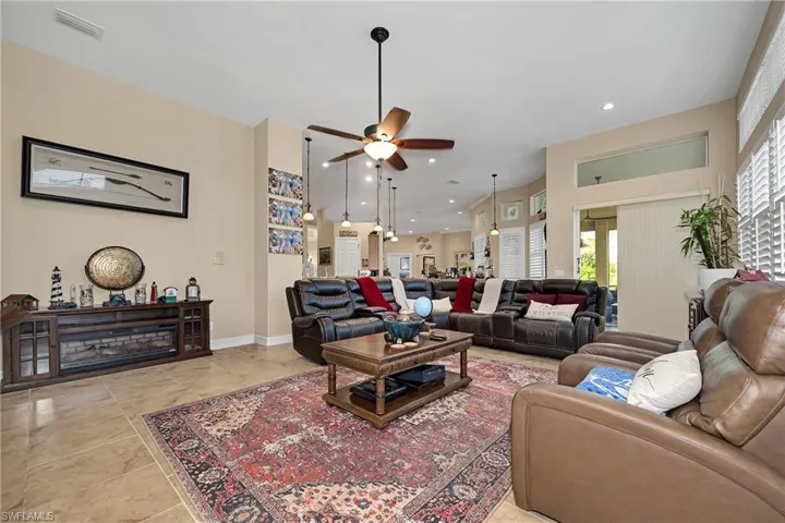 Living area with a ceiling fan, healthy amount of natural light, recessed lighting, and light tile patterned floors