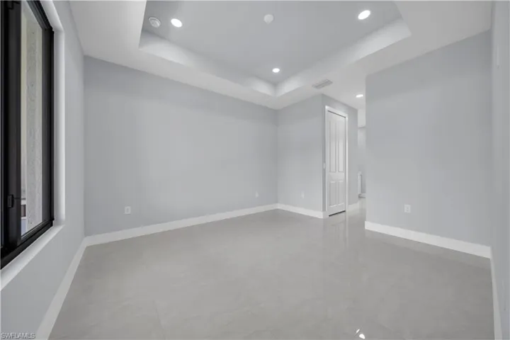 Recessed lighting, tray ceiling, tile flooring, and a multi-pane window