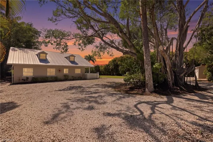 The property features a metal roof, two dormer windows, and a covered porch
