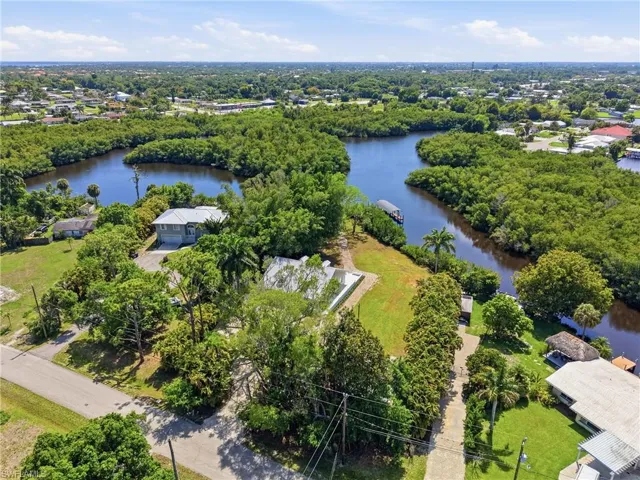 Aerial view showcasing the property's location with direct water access, surrounded by lush green trees
