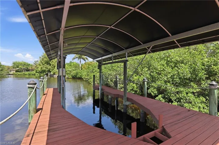 The property includes a private dock with a covered boat lift, providing direct water access