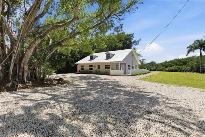 This property features a light-colored exterior with a metal roof and dormer windows