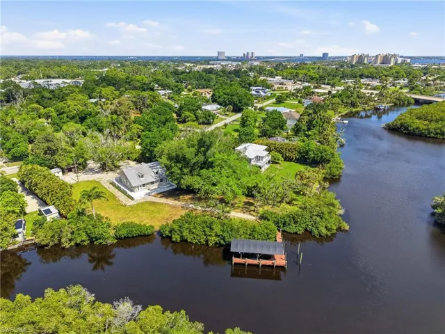 This aerial view highlights the property's waterfront location, featuring a private covered dock