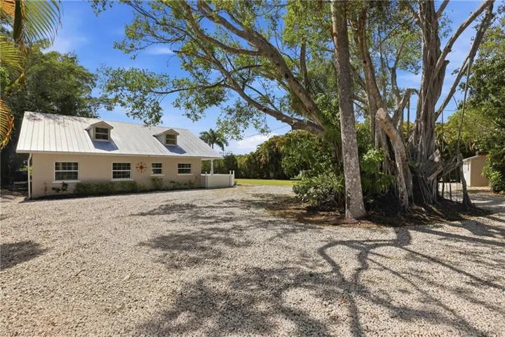 The property features a light-colored exterior with a metal roof and dormer windows