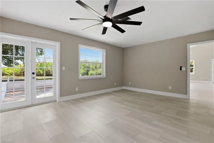 The property features light-colored tile flooring, neutral wall paint, and a modern ceiling fan
