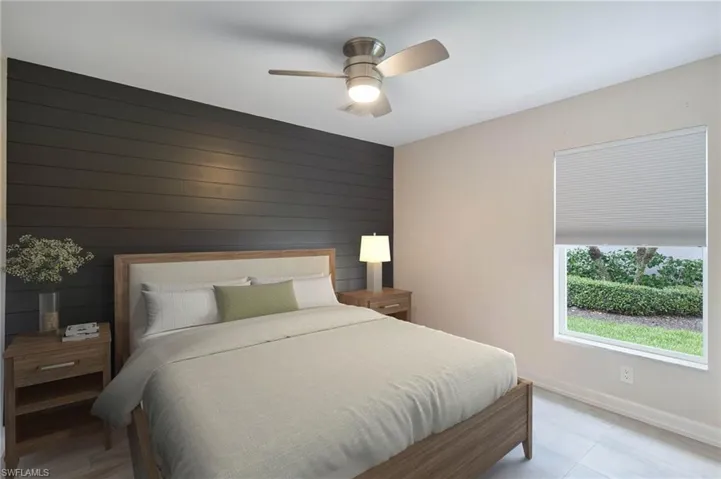 Bedroom featuring ceiling fan and wooden walls