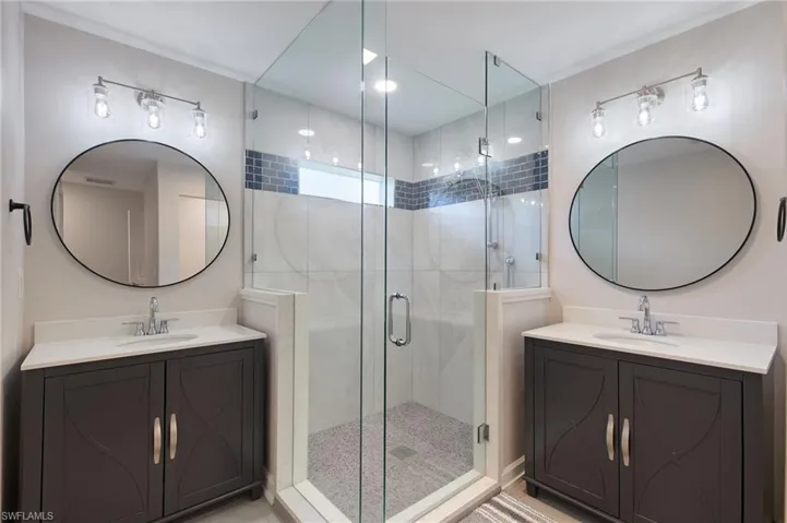 Bathroom featuring double sink vanity and an enclosed shower