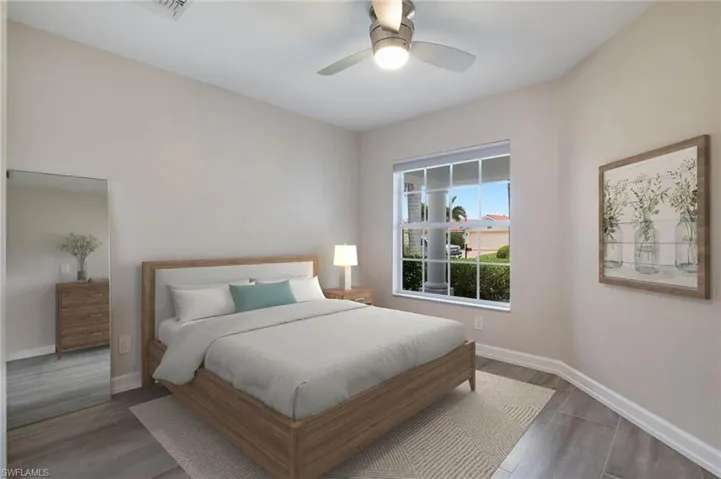 Bedroom with ceiling fan and dark wood-type flooring