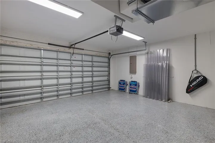 Garage featuring a garage door opener and electric panel