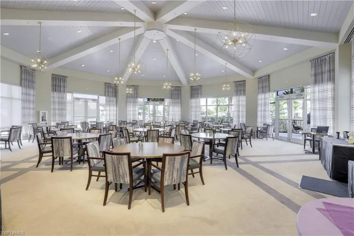 Carpeted dining room with high vaulted ceiling, a chandelier, and beamed ceiling