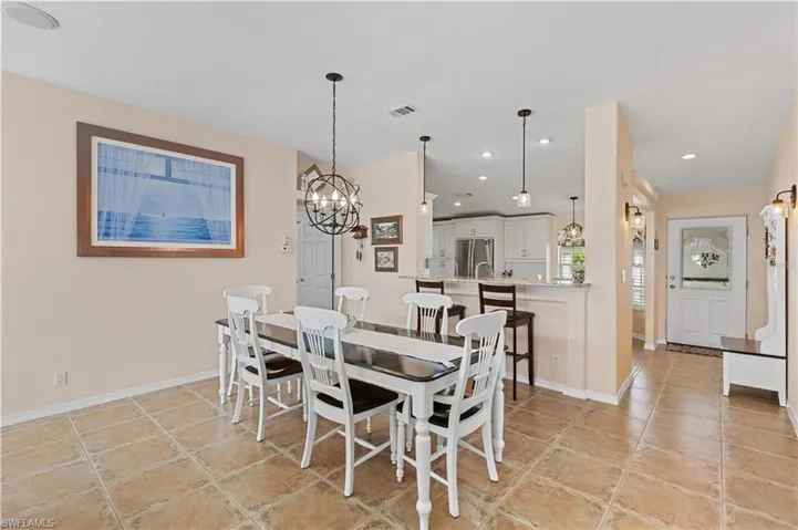 Dining room with suspended lighting and light tile patterned flooring