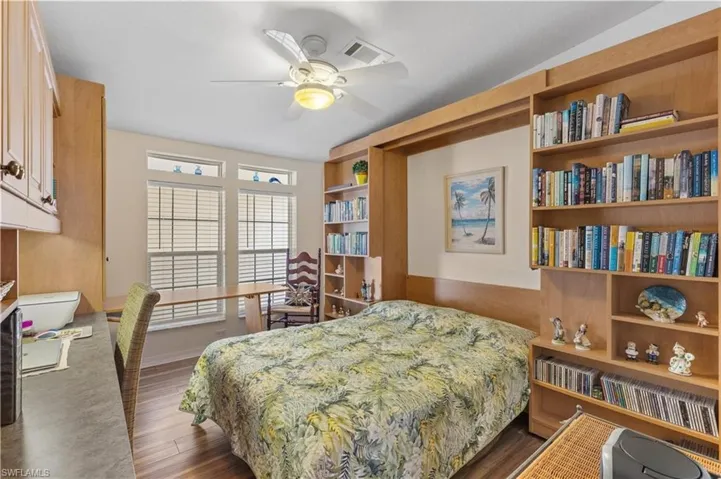 Bedroom featuring dark wood-style flooring, a desk, and a ceiling fan