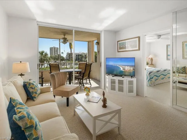 Living area featuring a ceiling fan, carpet, and floor to ceiling windows