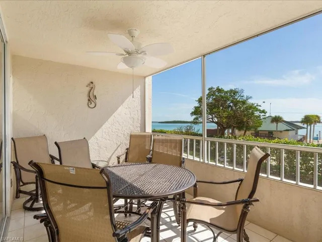 Balcony with ceiling fan, a water view, and outdoor dining space