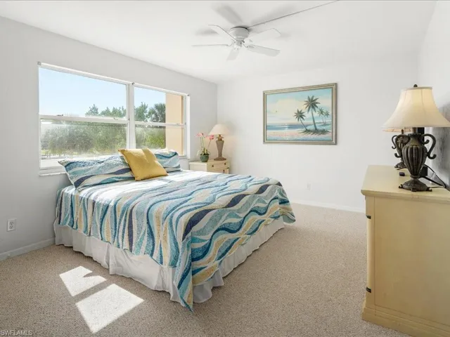 Carpeted bedroom featuring baseboards and ceiling fan