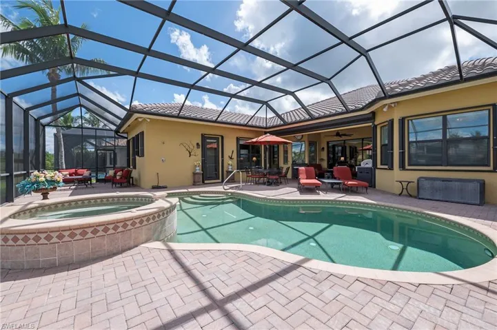 View of swimming pool with a lanai, outdoor lounge area, an in ground hot tub, a patio area, and ceiling fan