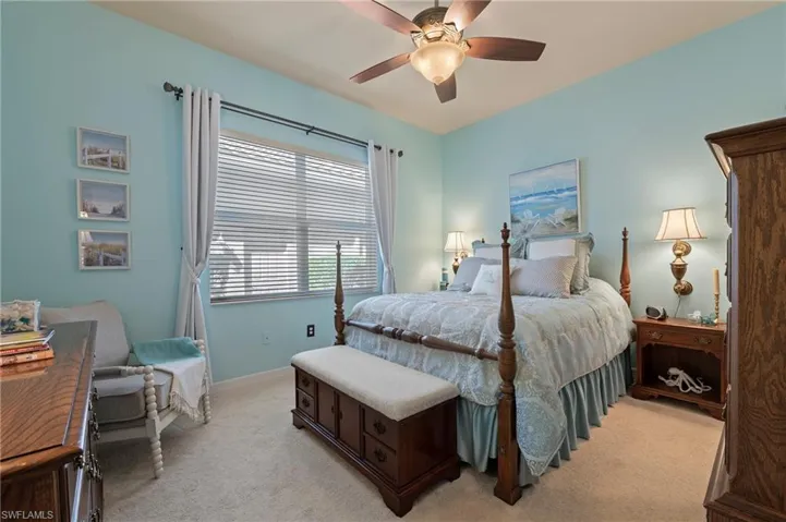 Carpeted bedroom featuring ceiling fan