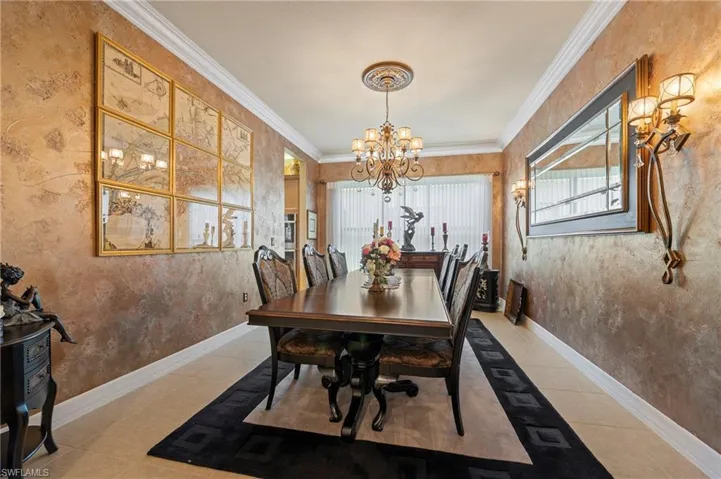 Tiled dining space with an inviting chandelier and crown molding