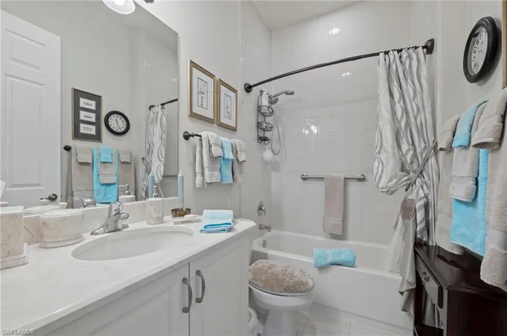 Full bathroom featuring tile flooring, shower / tub combo with curtain, vanity, and toilet