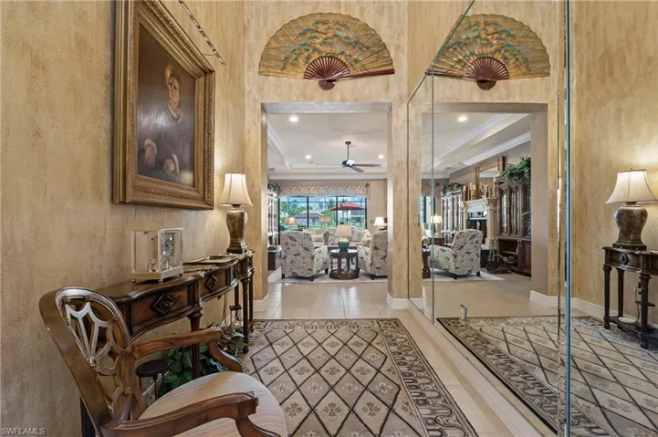 Entrance foyer featuring tile flooring, ceiling fan, and crown molding